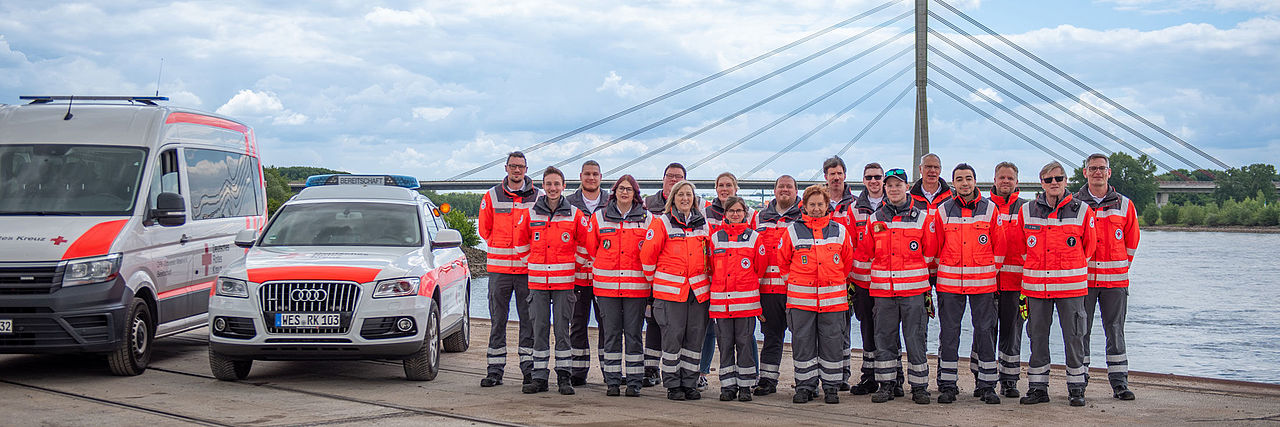 Mitglieder der DRK Bereitschaft Wesel mit Rheinbrücke im Hintergrund